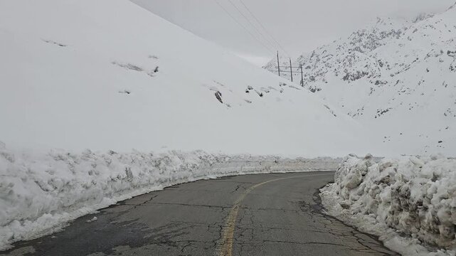 enjoying a winding snow-covered mountain road lined with tall snowbanks, leading toward distant snowy peaks under a cold, overcast winter sky.
📍Hawraman Takht, Kurdistan 