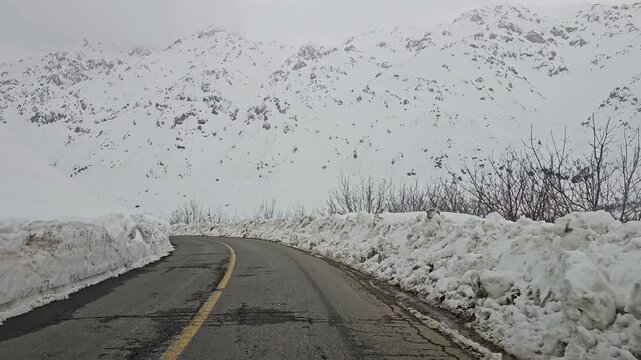 enjoying a winding snow-covered mountain road lined with tall snowbanks, leading toward distant snowy peaks under a cold, overcast winter sky.
📍Hawraman Takht, Kurdistan 