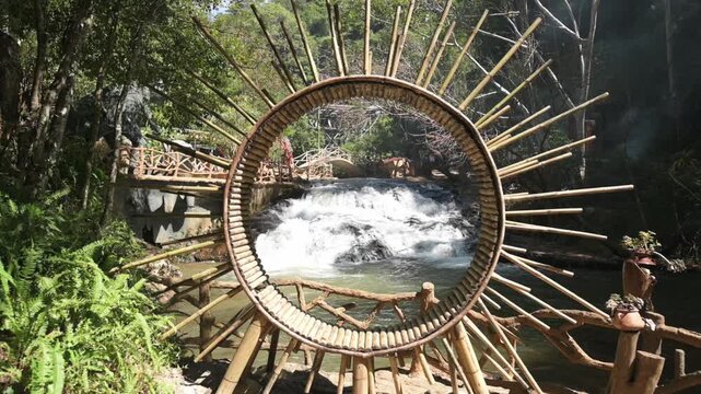 Datanla, Vietnam, Da Lat Bamboo Ring Frames Rushing Waterfall View, Handcrafted Circular Frame With Radiating Spokes, Riverscape Captured Through Center, Rustic Railing And Incense Smoke,