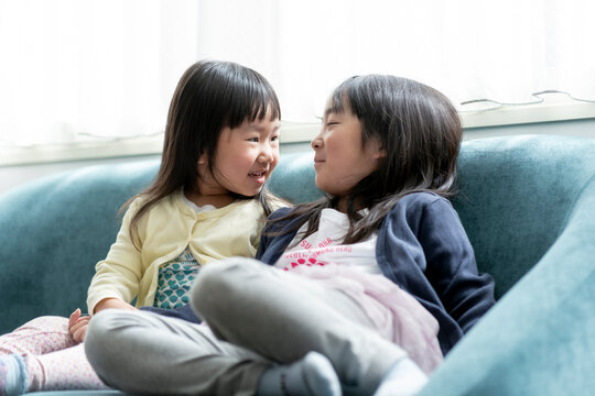 ソファーに座る幼い日本人姉妹