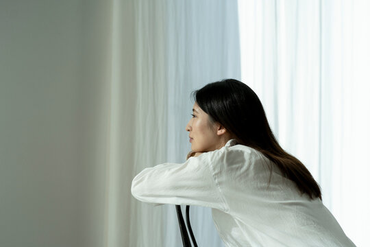 考え事をする若い日本人女性