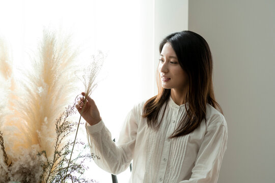 ドライフラワーを飾る若い日本人女性