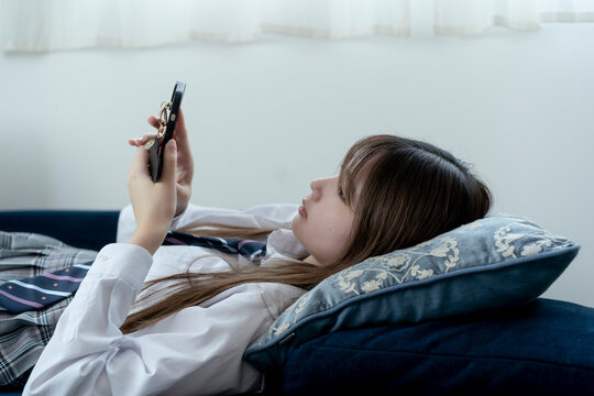 スマートフォンを見る日本人女子高生