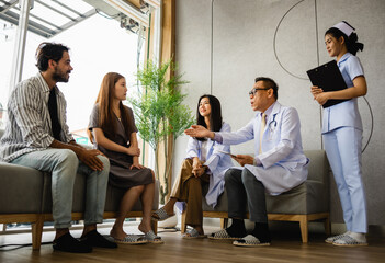 group of people are sitting in a room with a doctor