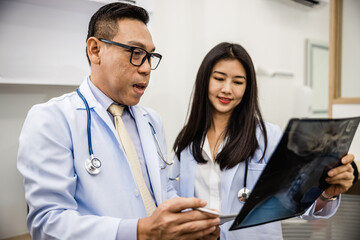 doctor and a nurse are looking at a X-ray