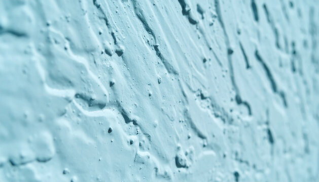Abstract Light Blue Stucco Wall Texture Background. Close-up of rough cement render with uneven surface and deep shadows in teal color saturation.