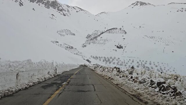 A snow-lined mountain road winding through snowy hills, rugged peaks, and distant tree lines under a cold, overcast winter sky.
📍Hawraman Takht, Kurdistan 