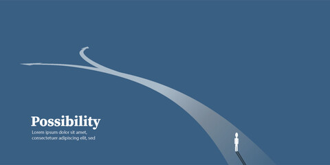 A person stands at a fork in a glowing path, symbolizing a choice, new direction, or future possibility on a dark blue background. © MohSamsudin