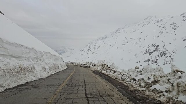 A twisting snow-covered mountain road bordered by high snow walls, winding through snowy hills and rugged peaks under a cold, overcast winter sky.
📍Hawraman Takht, Kurdistan 