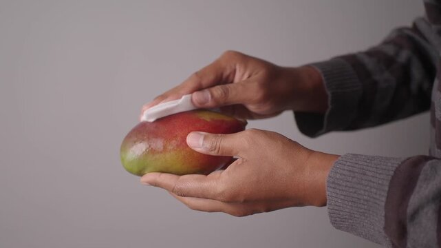 Cleaning a mango before slicing it for a snack