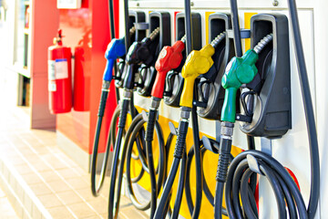 Row of colorful fuel pumps at gas station, each with different colored nozzle, ready for refueling vehicles. bright colors and organized arrangement create vibrant and efficient atmosphere © pirom