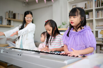 Children learning and playing piano happily in a bright living room, Teacher and girls engaging in music education with a keyboard and a smartphone