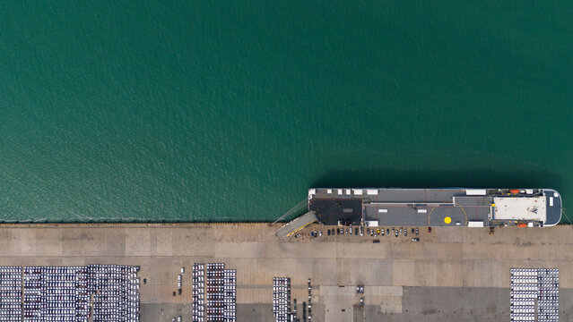 Top view of port, electric car shipping yard and intercontinental shipping industry.	