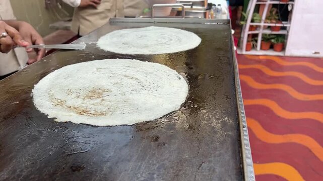 Cooking two plain dosa in an Indian wedding