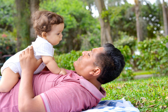 Tender multiracial family. Dad and a baby in the park.