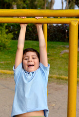 Fototapeta premium Active hispanic boy training on playground equipment.