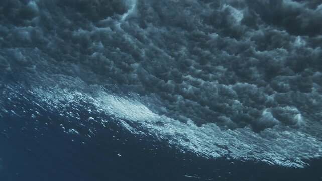 Underwater wave surface covered in fine bubbles forming subtle abstract ocean texture