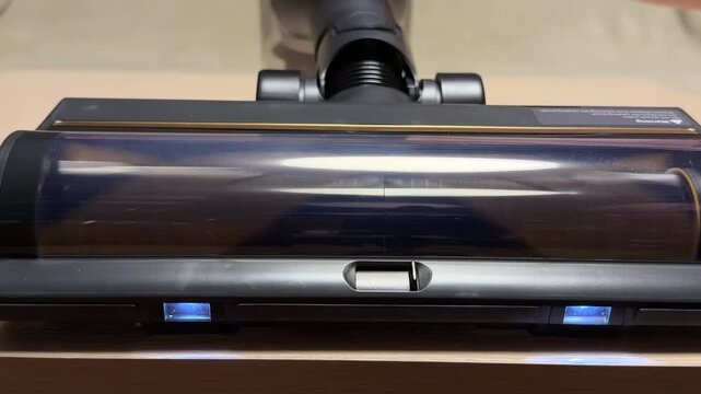 The motorized vacuum head spins its internal roller rapidly across the floor. This high-speed rotation generates a constant, mechanical whirring accompanied by a deep, powerful rushing air sound.