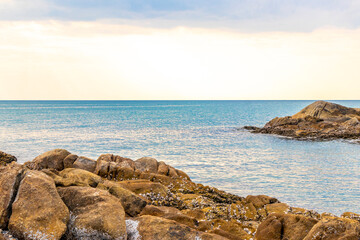 Rocky Kalim Beach turquoise blue clear water waves rocks Thailand.