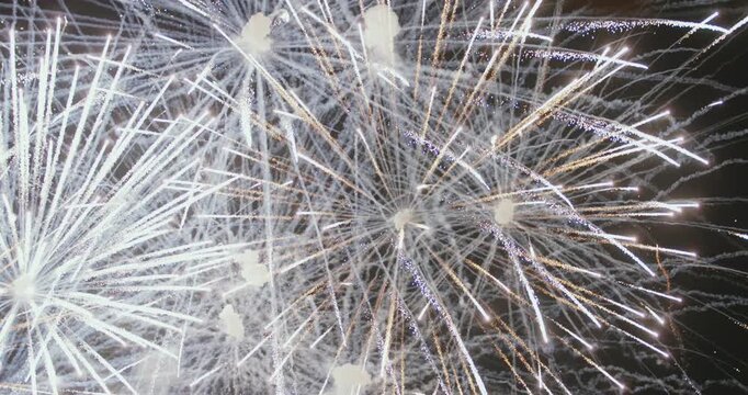 Close-up fireworks captured with a telephoto lens from short distance. Colorful explosions illuminating the night sky during the festive celebration of fallas in Valencia (nit del foc).
