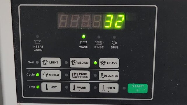 Electronic timer display on a washing machine shows decreasing numbers during the wash cycle. The digital countdown indicates remaining time and highlights modern appliance control and operation.
