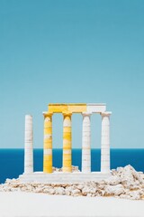 Fototapeta premium Ancient Temple Columns Standing on a Rocky Cliff Overlooking the Blue Sea under a Clear Sky, Historic Archaeological Site for Travel and Tourism Background with Copy Space
