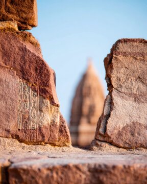 Ancient stone temple carvings and architectural details in a sacred historic site featuring warm clay tones and a blurred shrine background for travel and heritage