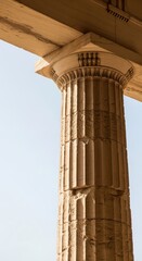 Obraz premium Ancient greek doric column with detailed fluting and capital against clear blue sky