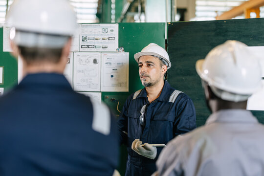 Professional senior lead supervisor engineer man training young engineer team in industry factory