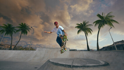 Skateboarder doing a trick in a skate park on sunset.