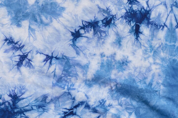 Close-up batik shirt with indigo blue dye on white fabric cotton background on top-view	
