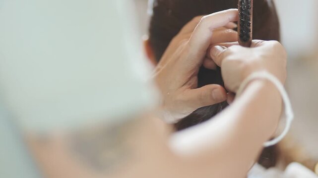 Master woman hairdresser dries the girl's hair with a hairdryer after washing in a beauty salon.