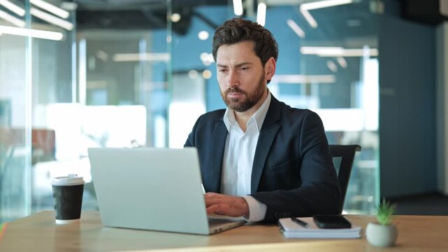 Banker works on laptop in modern office, displaying focused concentration transforming into a happy, satisfied smile. Captures emotions of successful task completion and positive work experience