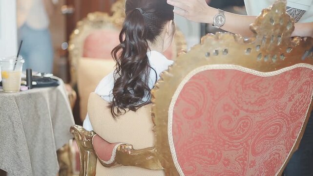 Master woman hairdresser dries the girl's hair with a hairdryer after washing in a beauty salon.