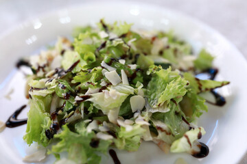 Fresh green salad with almond flakes and balsamic glaze