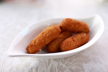 Golden fried croquettes served in white dish