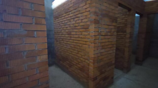 Brick hallway construction. A dark basement with low lighting and gloomy brick walls. High quality 4k footage