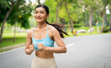 Fototapeta premium Young runner Asian woman jogging in park path, skinny fit in sports wear outfit leggings and top