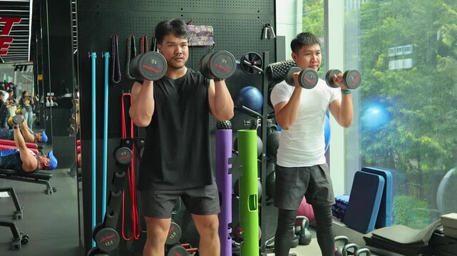 Personal Trainer Guiding Dumbbell Squat Exercise in Gym