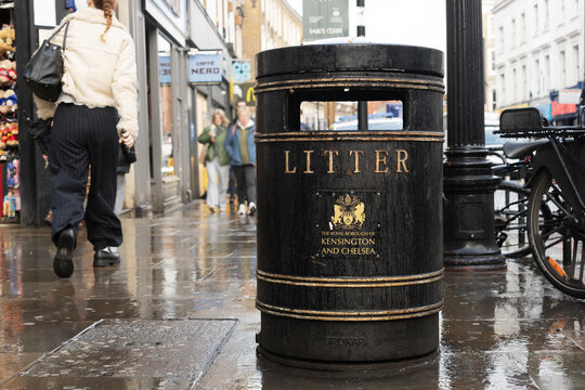 Litter bin of the Royal Borough of Kensington and Chelsea on rainy street in London