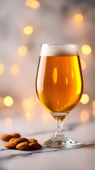 Beer glass with almonds on marble background with festive golden lights