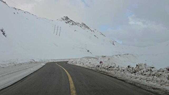 Enjoying a drive along a winding snow-covered mountain road with high snow walls, snowy hills, rugged peaks, and an overcast sky in a remote winter landscape.
📍Hawraman Takht, Kurdistan 