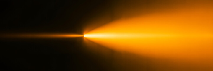 Obraz premium Dynamic Orange Light Beam and Horizontal Lens Flare Effect with Warm Glow on Abstract Dark Background
