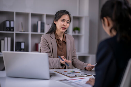 Asian businesswoman consulting client in office meeting