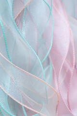A background of curved organza ribbons in pastel colors