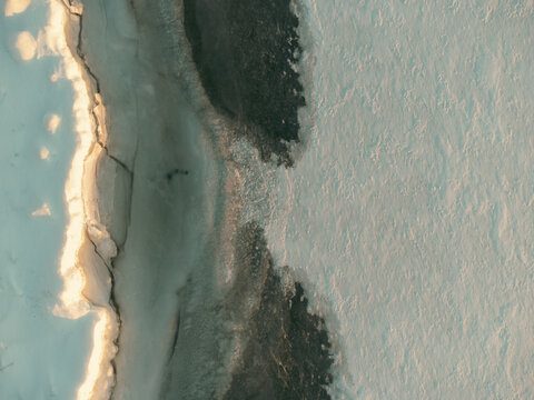 Frozen lake shows winter ice formation and dark water