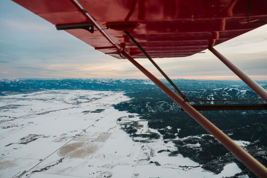 Snow covered plains and farmland viewed from small airplane.