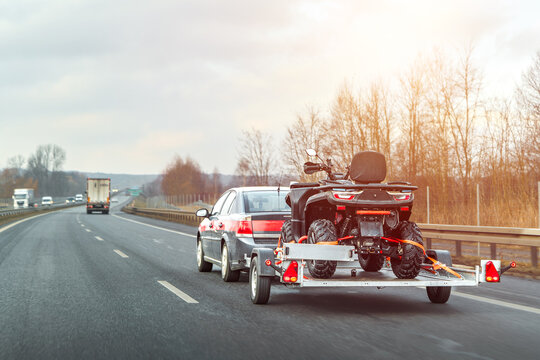 Car pulling trailer with dirt bike quad