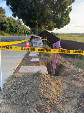 Yellow caution tape cordoning off a damaged irrigation sprinkler control box in Carlsbad.