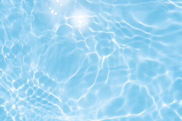 Obraz premium Blue water with ripples on the surface. Defocus blurred transparent blue colored clear calm water surface texture with splashes and bubbles. Water waves with shining pattern texture background.